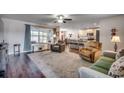 Spacious living room with hardwood floors, comfortable seating, and large windows at 575 Mossbank Loop, Longs, SC 29568