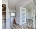 Bright entryway featuring stylish gray floors, staircase, and glass french doors to the office at 808 St. Albans Loop, Conway, SC 29526