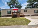 Tan mobile home with deck and red umbrella at 818 Wayne St., North Myrtle Beach, SC 29582