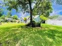 Landscaped yard with a mature tree overlooking a lovely home with white trim and verdant surroundings at 104 Willow Ridge Rd., Myrtle Beach, SC 29588