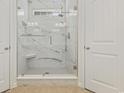 Luxurious walk-in shower featuring marble-look tile, a glass enclosure, and a rainfall shower head at 129 Yeomans Dr., Conway, SC 29526