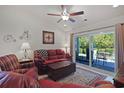Cozy living room featuring a red leather sofa, a coffee table, and access to a back patio at 132-A Machrie Loop # A, Myrtle Beach, SC 29588