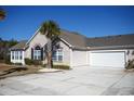 Tan house with stone accents, a two-car garage, and a palm tree in the front yard at 160 Stonegate Blvd. # 160, Murrells Inlet, SC 29576