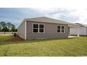 Rear view of gray house with a backyard and landscaping at 207 Jeff Waters Circle, Longs, SC 29568