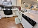 Kitchen featuring white appliances, wood-look flooring, and neutral backsplash, complemented by a blue rug at 270 Pinehurst Dr. # 9-I, Pawleys Island, SC 29585
