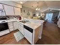 Bright kitchen open to the living area features a breakfast bar, white cabinets and modern appliances at 270 Pinehurst Dr. # 9-I, Pawleys Island, SC 29585