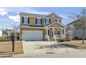 Two-story house with a white front porch, two-car garage, and landscaped yard at 327 Simplicity Dr., Murrells Inlet, SC 29576