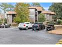 Exterior of the property showing parking spaces for residents and a golf cart and lush surrounding trees at 401 Indian Wells Ct. # 401, Murrells Inlet, SC 29576