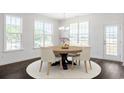 Bright dining area featuring hardwood floors, three windows with views, a modern light fixture, and exterior door at 4040 Bucolic Loop, Myrtle Beach, SC 29588