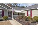 Welcoming front porch with landscaping and a red door at 1460 Abberbury Dr., Conway, SC 29527