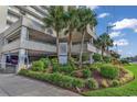 Oceanfront condo building entrance with landscaping at 1990 N Waccamaw Dr. # 1109, Garden City Beach, SC 29576