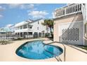 Inviting kidney-shaped pool with brick wall feature at 2179 South Waccamaw Dr., Garden City Beach, SC 29576