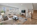Living area features white sofas, large TV, and hardwood floors at 2557 Pete Dye Dr. # 903, North Myrtle Beach, SC 29582
