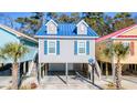 Beach house with gray siding, blue roof, and white trim at 4321 Grande Harbour Blvd., Little River, SC 29566