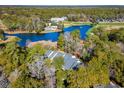 Scenic aerial view of a home on a wooded lot, a golf course, and a pond at 489-3 Golden Bear Dr. # 3, Pawleys Island, SC 29585