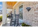 Cozy front porch featuring rocking chairs, brick detailing, and wood ceiling at 8050 Yamassee St. # A, Myrtle Beach, SC 29572