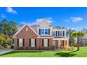 Charming two-story home with brick facade, black shutters, a well-manicured lawn and a neatly kept garden at 1303 Bermuda Grass Dr., Myrtle Beach, SC 29579