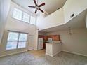 Open living room with high ceilings, kitchen bar, and neutral decor at 155 E Chenoa Dr. # E, Murrells Inlet, SC 29576