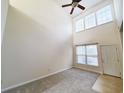 Open living room with high ceilings, neutral decor, and access to kitchen at 155 E Chenoa Dr. # E, Murrells Inlet, SC 29576