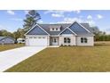 Newly constructed home with neutral siding and a three-car garage at 1900 Blue Bird Rd., Loris, SC 29569