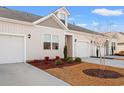 Tan townhome with white garage doors and landscaping at 3518 Bells Lake Circle # 215, Longs, SC 29568