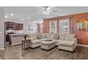 Open-concept living room with a sectional, hardwood floors, and a view into the kitchen at 421 Sunforest Way, Conway, SC 29526