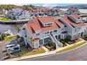 Expansive aerial view shows the beautiful gray condos, red roofs, manicured lawns, and community boat dock at 4396 Baldwin Ave. # 34, Little River, SC 29566