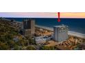 Expansive aerial view showcasing the condo building near the beach with a red arrow marking the top of the building at 5511 N Ocean Blvd. # 302, Myrtle Beach, SC 29577