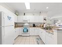 Bright kitchen featuring white cabinets, granite countertops, and modern appliances at 601 Hillside Dr. N # 1506, North Myrtle Beach, SC 29582