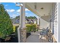 Inviting front porch with stone columns, a bench, and potted plants at 626 Notting Hill Ct., Conway, SC 29526