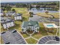 Aerial view of condo complex, lake, golf course and pool with lounge chairs at 677 Tupelo Ln. # 301, Longs, SC 29568