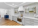 White kitchen features marble counters and unique tile backsplash at 8500 Margate Circle # 109, Myrtle Beach, SC 29572