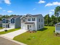 New two-story houses with gray and beige siding, two-car garages, and grassy yards at 1041 Kinness Dr., Conway, SC 29527