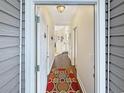 Bright hallway featuring wood floors, neutral walls, and a colorful rug creating a warm welcome at 1109 Peace Pipe Ln. # 201, Myrtle Beach, SC 29579