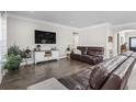 Comfortable living room features hardwood floors, a brown leather sofa, and a wall-mounted television at 2450 Craven Dr., Myrtle Beach, SC 29579