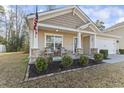 Inviting front porch featuring stone columns, outdoor seating, and lovely landscaping, perfect for relaxation at 261 Sea Turtle Dr., Myrtle Beach, SC 29579