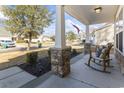 Charming front porch with stone columns and cozy rocking chairs offers a relaxing outdoor space at 261 Sea Turtle Dr., Myrtle Beach, SC 29579
