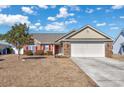 Brick front house with a large white garage door and red shutters at 2623 Corn Pile Rd., Myrtle Beach, SC 29588