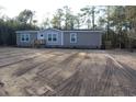 Tan mobile home with wood deck and landscaping at 2901 N Nichols Hwy., Nichols, SC 29581