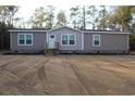 Tan mobile home with wood deck and landscaping at 2901 N Nichols Hwy., Nichols, SC 29581