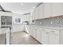Bright kitchen boasts white cabinets, backsplash, stainless steel appliances and recessed lighting at 3545 Marion Ln., Murrells Inlet, SC 29576