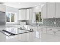 Kitchen features a central island with stainless steel appliances, quartz counters and a subway tile backsplash at 3545 Marion Ln., Murrells Inlet, SC 29576