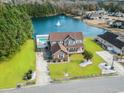Expansive aerial view featuring a home with lush landscaping, a backyard pool, and picturesque lake views at 400 Dog Pen Ct., Myrtle Beach, SC 29579