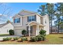Delightful two-story home with a single-car garage, featuring a brick-accented porch and lush landscaping at 413 Cotton Grass Dr., Loris, SC 29569