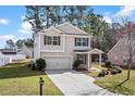 Two-story home boasting manicured lawn, brick-accented porch, and extended driveway leading to a single-car garage at 413 Cotton Grass Dr., Loris, SC 29569