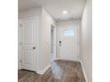 Bright entryway with white door, wood-look floors, and neutral walls at 4131 Robin Song Way, Loris, SC 29569