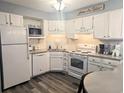 Cozy, bright kitchen with white cabinets, modern appliances, decorative back splash, and gray countertops for a beachy vibe at 4305 N Ocean Blvd. # 205, North Myrtle Beach, SC 29582