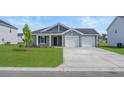 Charming single-story home showcasing a well-manicured lawn and a two-car garage at 57 Cape Point Dr., Conway, SC 29527