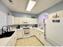 L-shaped kitchen with white cabinets and tile backsplash at 5801 Oyster Catcher Dr. # 1812, North Myrtle Beach, SC 29582