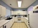 L-shaped kitchen with white cabinets and tile backsplash at 5801 Oyster Catcher Dr. # 1812, North Myrtle Beach, SC 29582